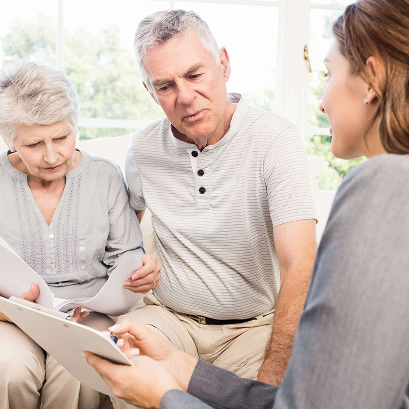 Fachberaterin sitzt mit einem älteren Ehepaar und Bespricht Vorschläge